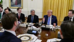 Trump speaks at a long table at the White House luncheon, with Nvidia CEO Jensen Huang, other guests, and a Vice President place card nearby.